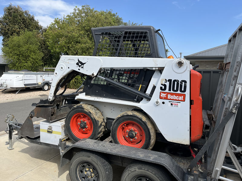 Bobcat S100 skid steer loader on a trailer