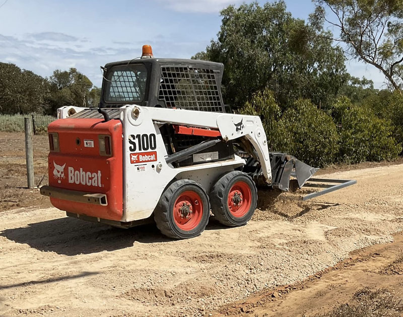 Bobcat S100 skid steer loader levelling a gravel surface